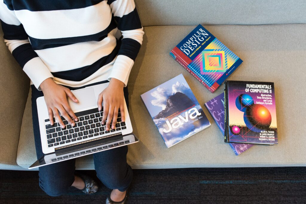 Person uses a computer near programming books