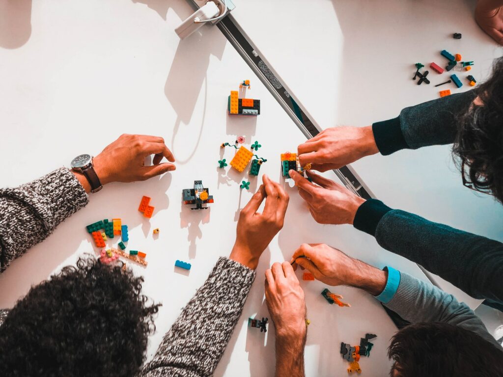 Three people playing with mounting bricks