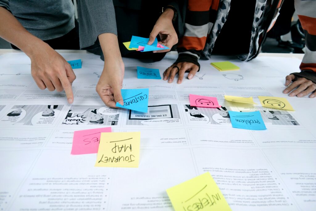Group performing UX Research handling colorful post-its with their hands