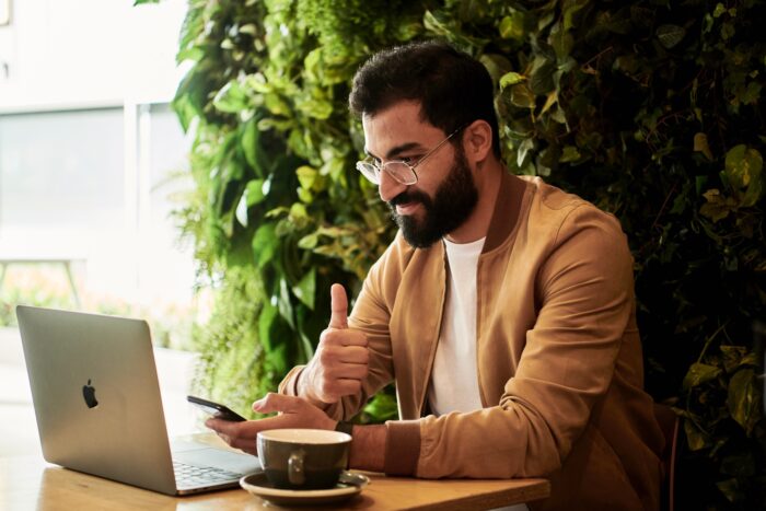 Person using computer and showing thumbs up