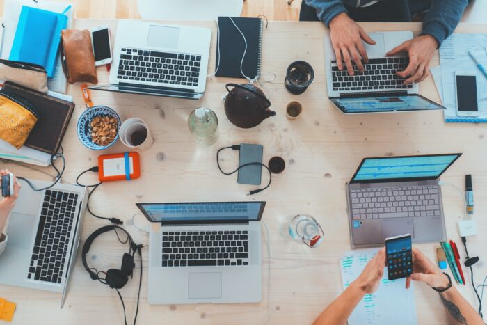 Top view of a work desk with computers and electronic apparels for a Kambu blog article